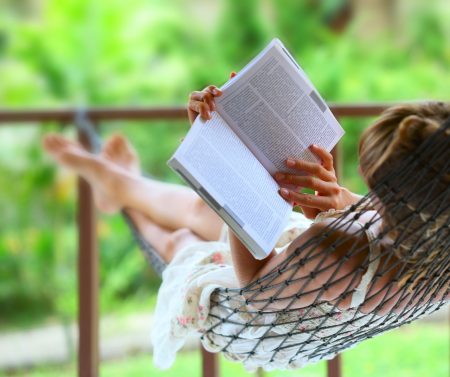Woman in hammock reading book